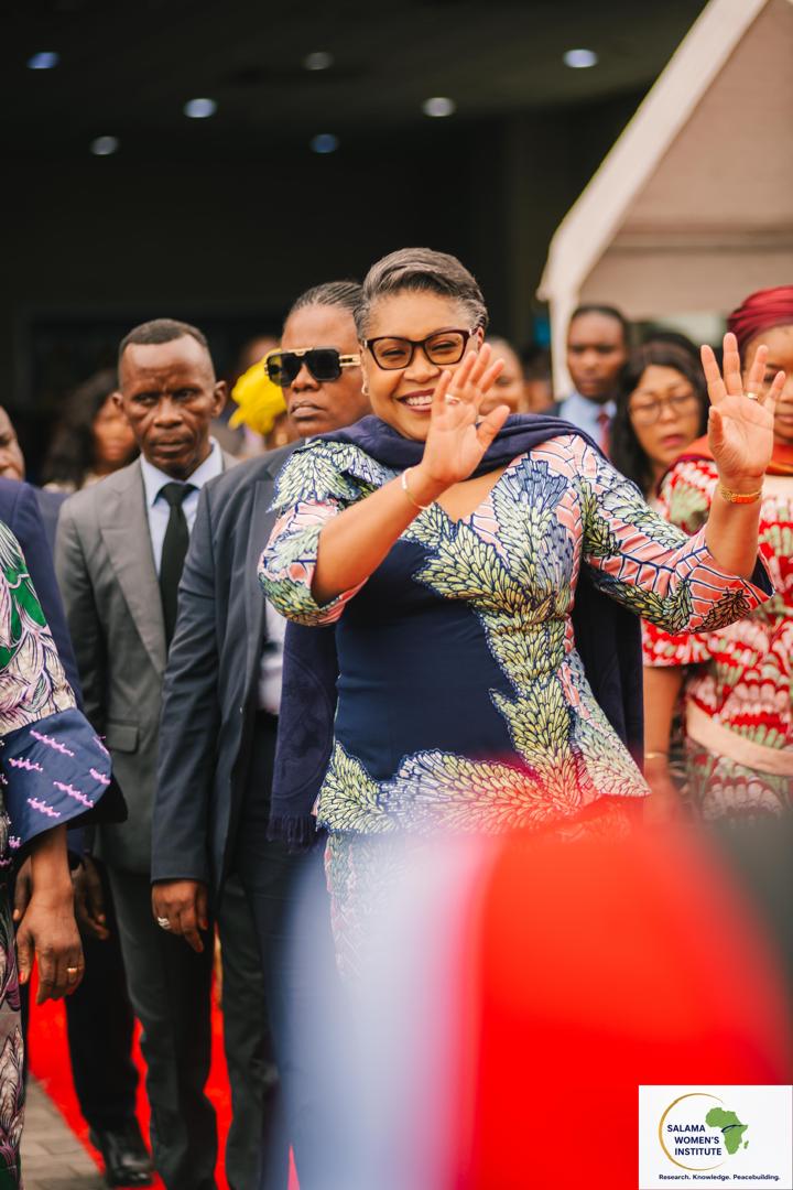 Femme souriante saluant la foule lors d'une célébration de la parité
